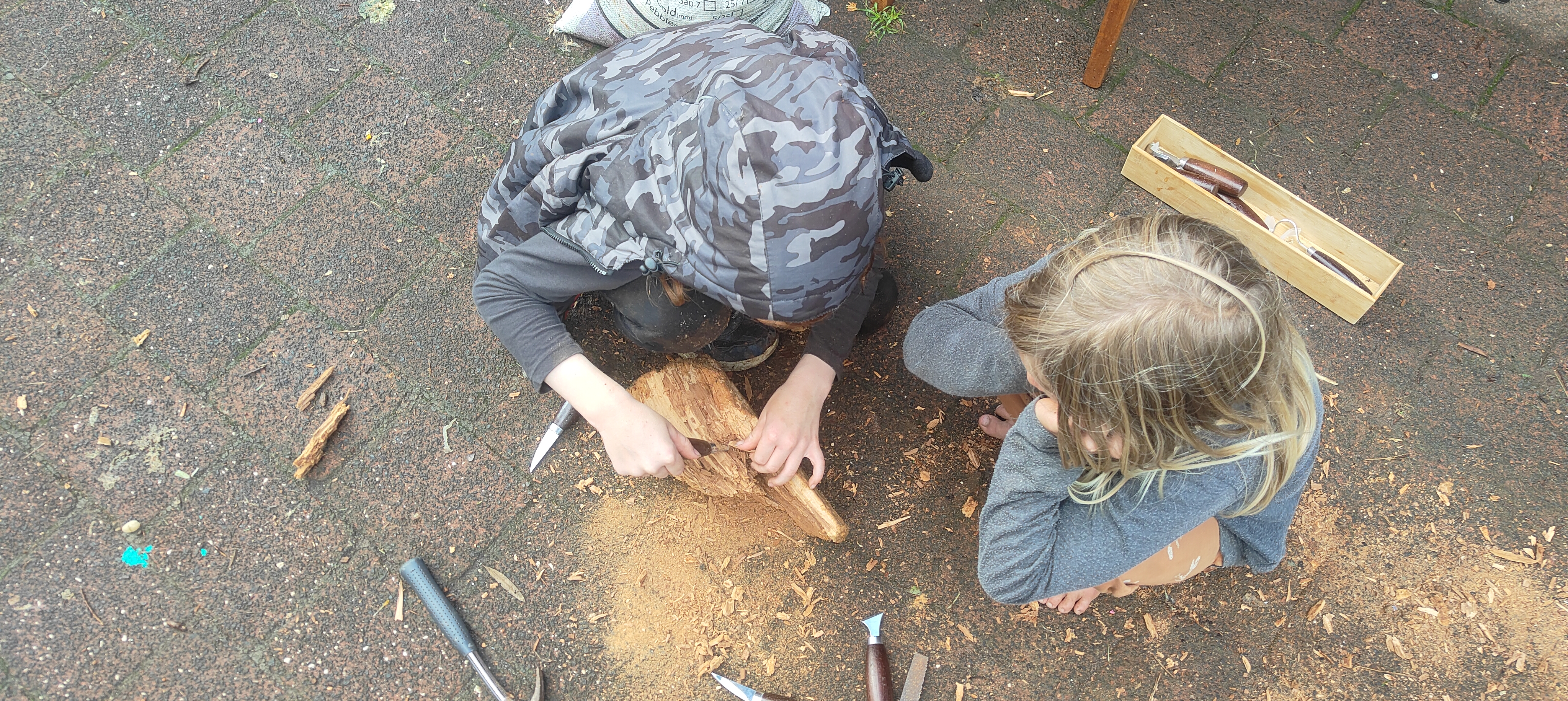 Children learning to whittle with real tools at The Bush Base